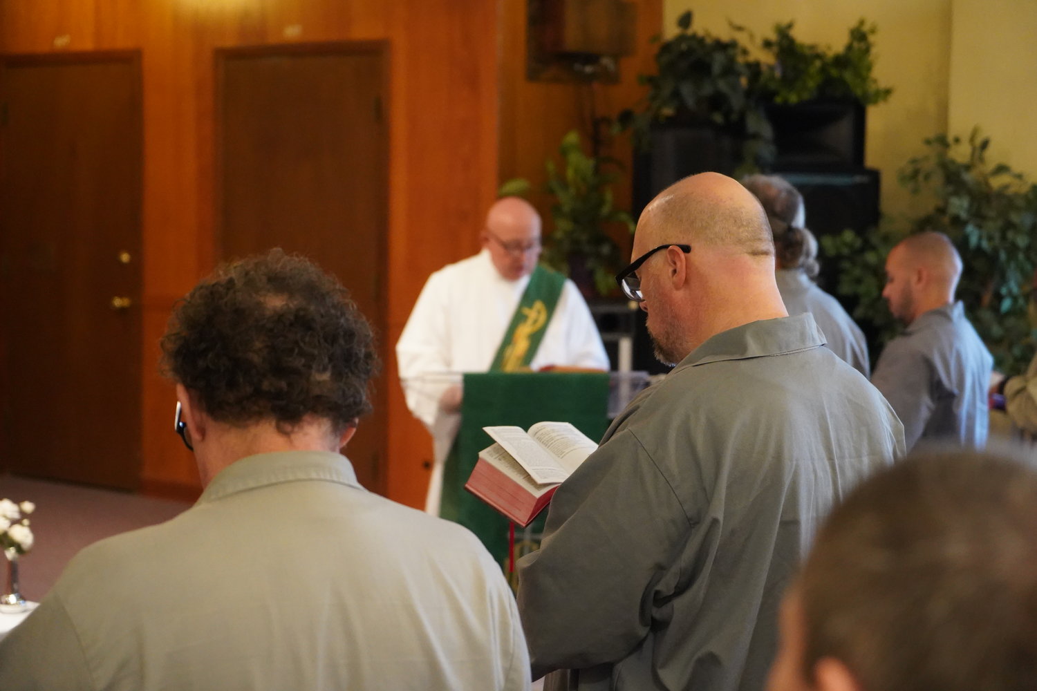 A resident of the Algoa Correctional Center in Jefferson City follows along in a Missal during a Nov. 6 Mass offered by Bishop W. Shawn McKnight and Father Michael Penn in the prison chapel.